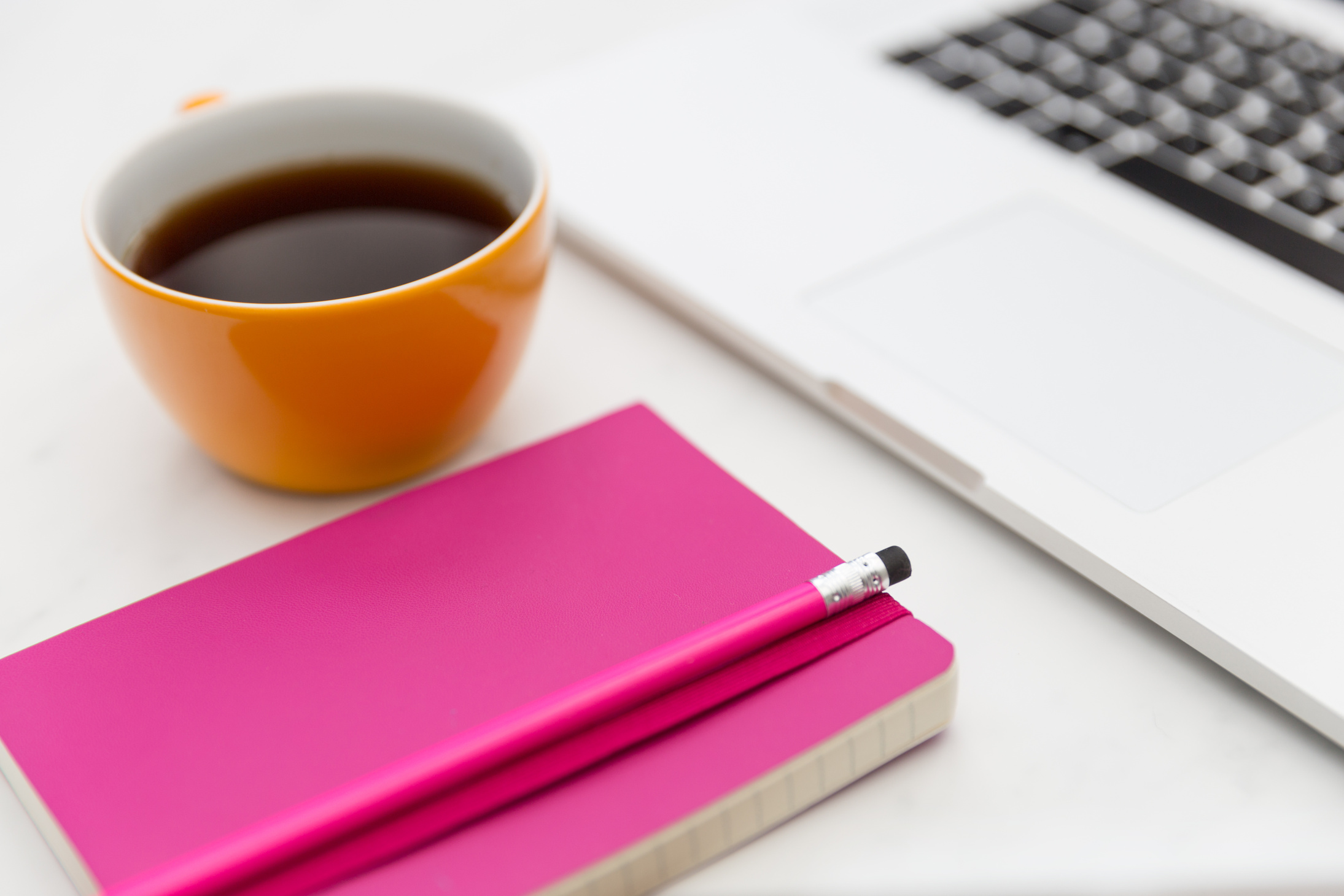 Coffee Cup and Bright Pink Notebook in Office